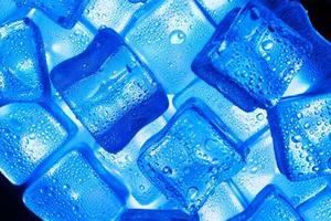 is kuber med vatten droppar spridd på en blå bakgrund, topp se. foto