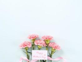 mors dag bakgrund, nejlika knippa - skön blek rosa blomma bukett isolerat på pastell blå tabell, topp se, platt lägga, kopia Plats design. foto