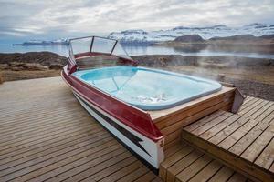 ett ikoniska båt varm badkar utanför de lokal- gästhus av mjoeyri nästan eskifjordur stad av öst fjord av island. foto