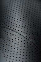 närbild fullskärm svart texturerad läder med perforeringar foto