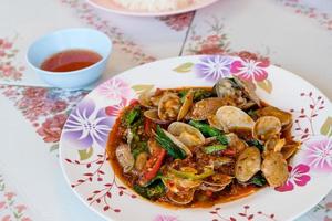 Vispa friterad musslor med rostad chili klistra på bord, thai mat foto