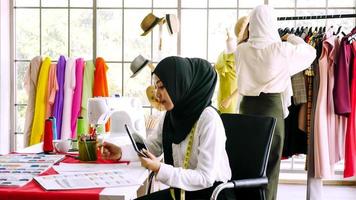 skön muslim kvinnor arbetssätt tillsammans på de Kläder kontor. foto