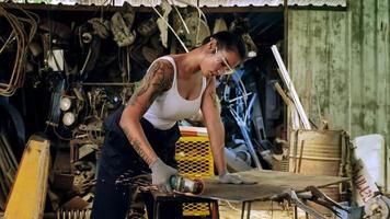 attraktiv ung kvinna mekanisk arbetstagare reparation en årgång bil i gammal garage. foto
