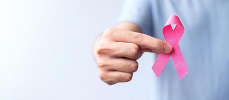 rosa oktober bröst cancer medvetenhet månad, man håll rosa band för Stöd människor liv och sjukdom. nationell cancer överlevande månad, mor och värld cancer dag begrepp foto
