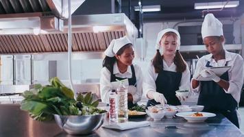 grupp av skol har roligt inlärning till laga mat. kvinna studenter i en matlagning klass. foto