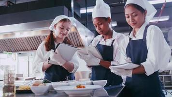 grupp av skol har roligt inlärning till laga mat. kvinna studenter i en matlagning klass. foto