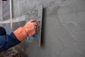 murverk arbetare använda sig av cement murslev på konstruktion webbplatser. foto