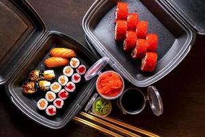 uppsättning läckra sushirullar med wassabi och ingefära i en låda. japansk mat. foto