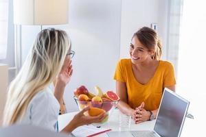 porträtt av ung leende kvinna dietist i de samråd rum. framställning diet planen. ung kvinna besöker dietist i vikt förlust klinik foto