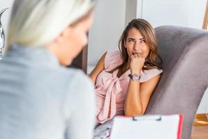 kvinna på terapi session. uppmärksam psykolog. ung kvinna på psykoterapi tänkande handla om råd hon mottagen foto