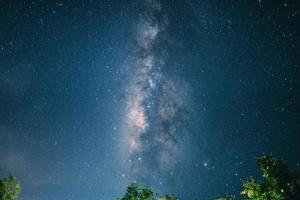 natt scen mjölkig sätt bakgrund, träd mot himmel på natt foto