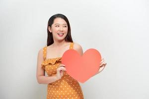 Färg vertikal bild av en flicka på vit med en stor röd hjärta foto