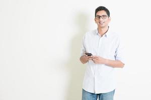 avslappnad indisk man som använder mobilappar