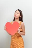 kvinna innehav stor röd hjärta på vit bakgrund foto