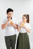 en ung Söt asiatisk par med en glasögon av orange juice foto