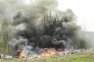 brand på landsbygden. svart rök och eld. det är östläge. foto