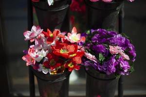 blommor är såld på gata. artificiell blommor för kyrkogård. detaljer av blomma affär. blommor tillverkad av plast. foto