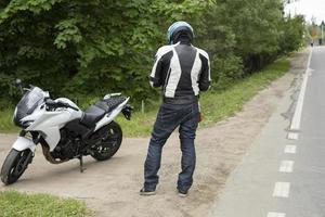 motorcyklist är stående på väg. sporter cykel. man i hjälm. foto