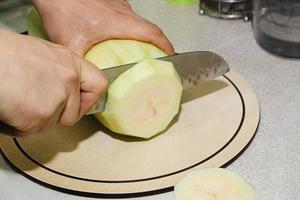 recept på zucchinifritter. steg 2 - skär zucchini. händerna skär grön zucchini i kuber. foto