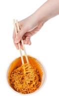 hand håller ätpinnar i kokta omedelbar spaghetti foto