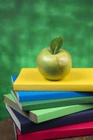 äpple frukt på topp av en bok stack, på de tillbaka av skola klasser. foto