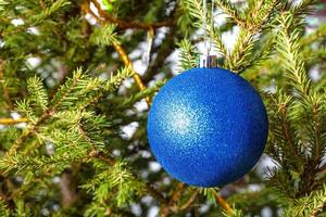 blå boll på kvistar av naturlig jul träd foto