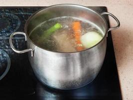 sjuder kött stock i stockpot på keramisk spis foto