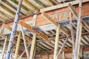 bambu ställningar stöder betong balk på hus byggarbetsplats foto