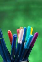 kreativitet av färgrik färgad penna i penna fall med kopia Plats på suddig bokeh grön bakgrund foto