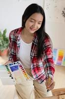 ung flicka målning på papper på Hem, trä ram, hobby och konst studie på Hem. foto