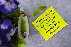motiverande och inspirera Citat på gul notera med blommor. foto