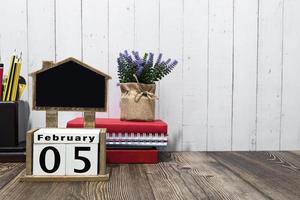 februari 05 kalender datum text på trä- blockera med brevpapper på trä- skrivbord. foto