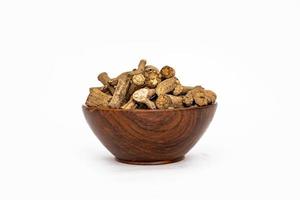 ayurvediska ört eller folk medicin hemidesmus indikation eller nannari eller indisk sarsaparill torkades rötter i trä- skål foto
