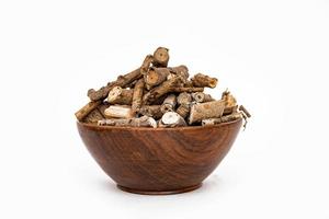ayurvediska ört eller folk medicin hemidesmus indikation eller nannari eller indisk sarsaparill torkades rötter i trä- skål foto