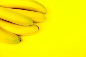 knippa av bananer på en gul bakgrund foto