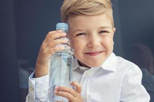 Lycklig barn med vatten flaska. foto