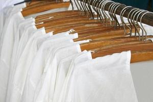 rad av vit shirts hängande på foto