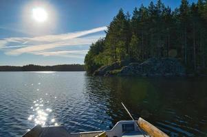 en fiske båt på en sjö i Sverige i smalland. blå vatten, solig himmel, skogar foto