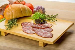 salami på trä- styrelse och trä- bakgrund foto