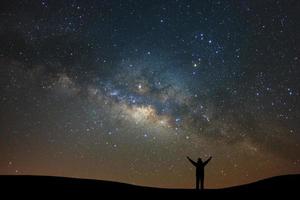 natt landskap med mjölkig sätt och silhuett av hög fjäll, starry himmel med stjärnor. skön universum. Plats bakgrund foto