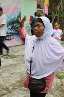 ett gammal kvinna dans och njuter musik. foto