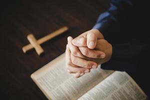 hand vikta i bön till Gud på helig bibel bok i kyrka begrepp för tro, andlighet och religion, kvinna person bön- på helig bibel i morgon. kristen katolik kvinna hand med bibel dyrkan. foto