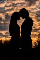 silhuett av romantiska par i kärlek, man och kvinnor i solnedgången himlen. romantisk av relationer mellan par kärlek i trädgården foto