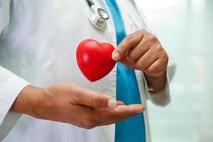 asiatisk kvinna läkare håller rött hjärta för hälsa på sjukhus. foto