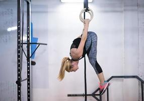 kvinna arbetssätt ut på gymnastiska ringar foto