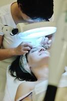 kvinna med ansiktsbehandling mask i kosmetisk studio foto