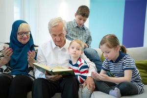 modern muslim farföräldrar med barnbarn läsning quran foto