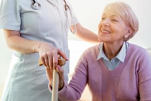 närbild av person rörande hand av senior kvinna. Hem bistånd begrepp. äldre kvinna hand innehav hand av ung vårdgivare på amning hem.geriatrisk läkare eller geriatriker begrepp. foto