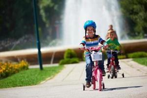 Lycklig pojke inlärning till rida hans först cykel foto