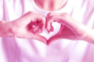 suddigt bild av hand tecken till vara hjärta form, som visar kärlek i rosa Färg tona Foto. foto